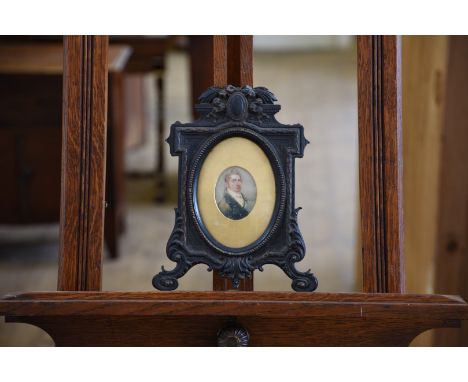 A 19th century portrait miniature of a young man wearing a green overcoat and white neckerchief.  2 by 2½ins.  In a gold moun