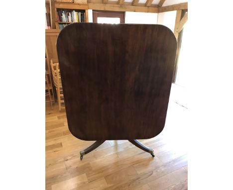 A Victorian mahogany tilt-top breakfast table, on a substantial turned stem, tripod reeded out-splayed legs and brass paw cas