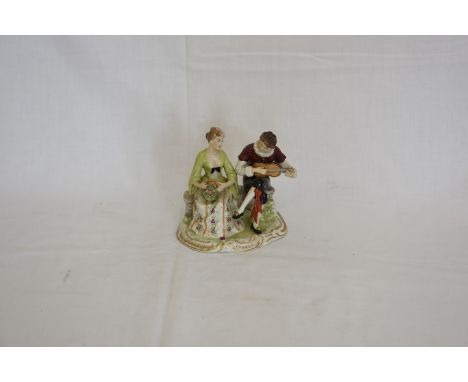 A German porcelain figural group depicting a gentleman playing a guitar and a lady holding a basket of flowers (af).  Est £10