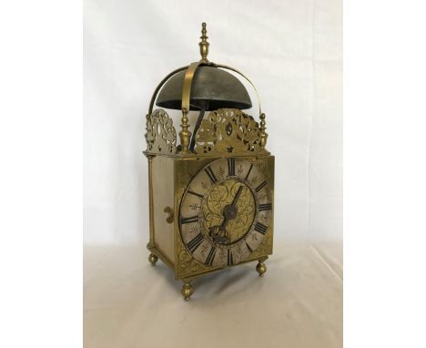 An 18th century brass cased lantern clock, the bell arched top with pierced brass front plate depicting mythical sea creature