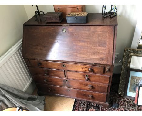 A George III mahogany bureau, the fall-flap opening to reveal a pigeonholed interior with secret compartments, drawers and cu