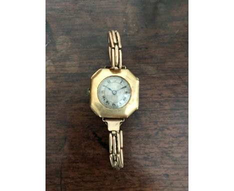 A 15ct gold cased wristwatch, the silvered engine turned dial with roman numerals and on a gold coloured metal elasticated st