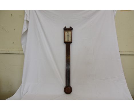 A 19th century mahogany and marquetry inlaid stick barometer with broken arch pediment and silvered back plate above a visibl