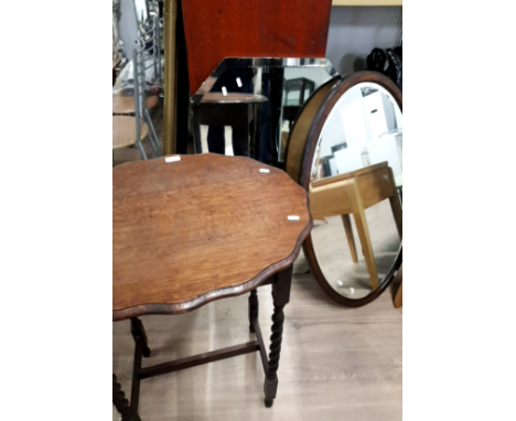 AN OAK BARLEY TWIST OCCASIONAL TABLE WITH ONE VINTAGE OVAL FRAMED BEVELLED MIRROR AND ONE UNFRAMED BEVELLED MIRROR