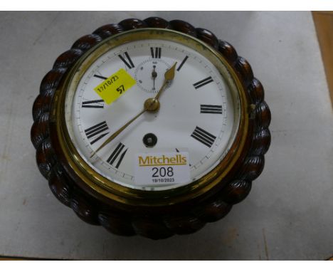 Brass bulkhead style clock in carved oak surround, 19 cm diameter