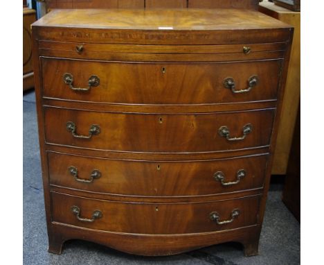 A mahogany bow front bachelor's chest, cross banded top, brushing slide over four drawers, brass swing handles, shaped skirt,