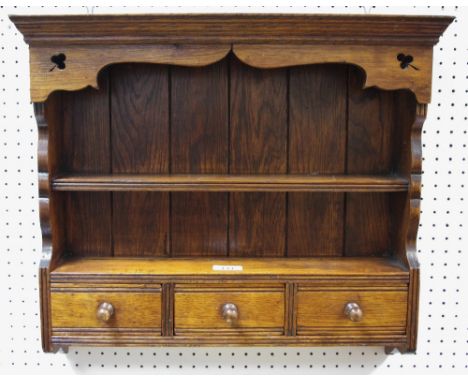 An oak wall hanging spice rack, two open shelves above three drawers, shaped cresting, pierced clover corners, 46cm x 49cm
