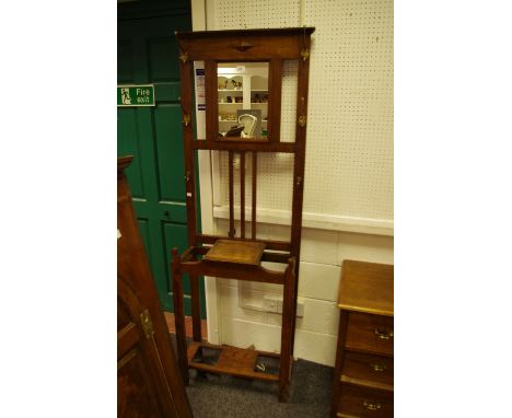 A 1940's oak hall stand, rectangular mirror, flanked by hooks, glove box and stick stand to base