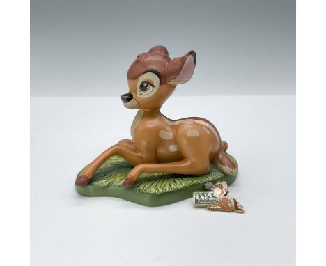 This Walt Disney sculpture is hand-decorated and depicts young Bambi sitting in the grass. This item has its original box. Ce