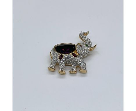 Trunk up for good luck on this gold plated elephant pin. Decorated with clear and red crystals, and a single green eye. Swaro
