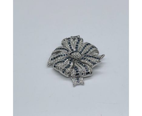 Beautiful rhodium plated bow enhanced with clear and dark blue crystals. Swarovski backstamp. This item has its original box.