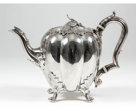 A good William IV silver melon shaped teapot, the leaf pattern lid with leaf finial, with leaf capped scroll handle and spout