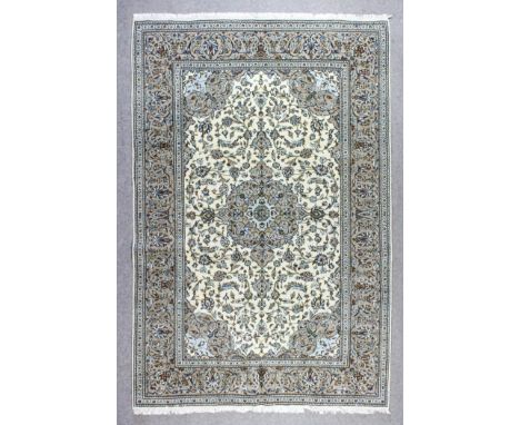 A Kashan carpet woven in muted shades with bold central medallion and conforming spandrels, the field filled with conforming 