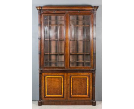 A late 19th Century mahogany bookcase with deep moulded cornice and rounded front corners with turned and fluted pillars to f