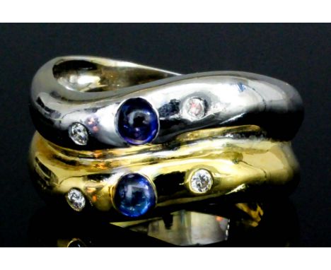 An 18ct yellow and white gold mounted sapphire and diamond ring, the twin bands each set with a small cabochon sapphire flank