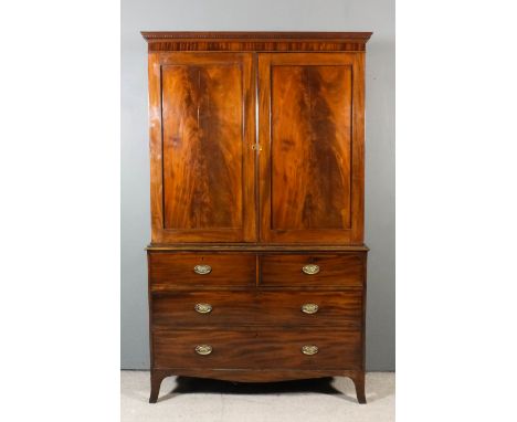 A George III gentleman's mahogany wardrobe, the upper part with moulded and dentil cornice, now fitted with ten adjustable sh