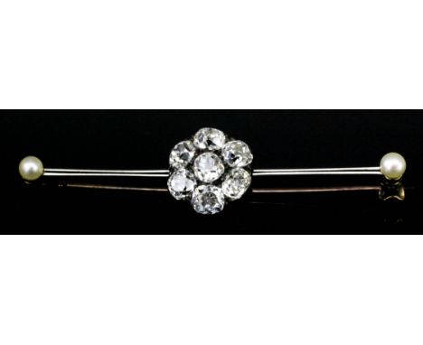 A white and yellow coloured metal mounted diamond and seed pearl bar brooch, the centre set with seven cluster diamonds (each
