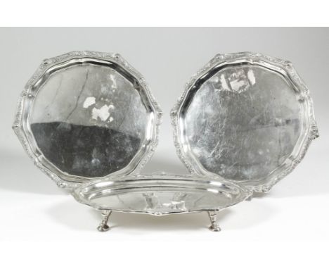 A pair of George VI silver circular waiters, the shaped and moulded rims cast with Celtic design, on three scroll pattern fee