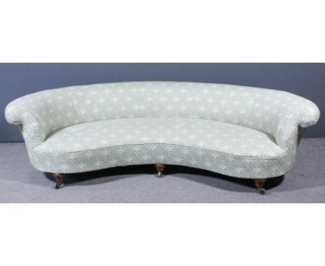 A late Victorian Howard &amp; Sons crescent shaped scroll back settee upholstered in green and cream cloth, on three bulbous 