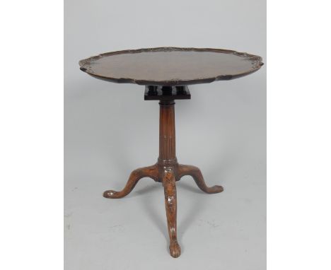 George III mahogany tilt top tea table, the circular bird cage top with carved floral scroll border, on a stop fluted pillar 