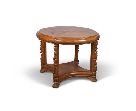 AN ART DECO FRENCH OAK CIRCULAR CENTRE TABLE the quarter-veneered top raised on carved legs joined by a concave shelf stretch