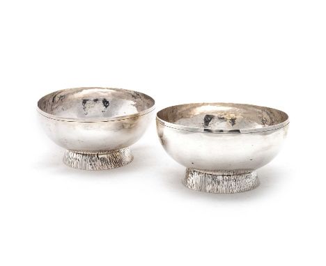 A PAIR OF ELIZABETH II SILVER BOWLS by Walter Edward King, London 1972, the round bowls with spot-hammered interior, raised o