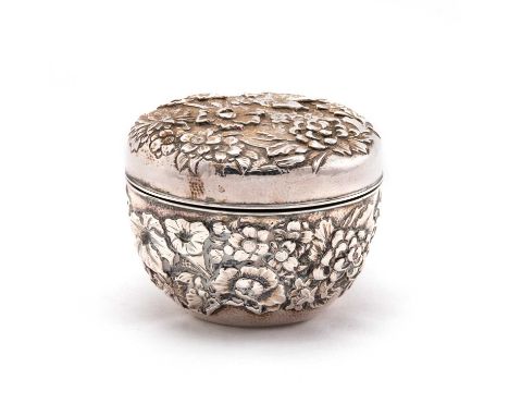 A JAPANESE SILVER BOX AND COVER signed, Meiji period, the rounded body and cover repoussé with flowers. 9cm diameter, 6.5 tro