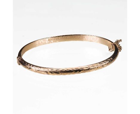 A 9 CARAT YELLOW GOLD HINGED BANGLE chased detail to half. 6.5cm wide, 6.1 grams grossGenerally good overall, wear commensura