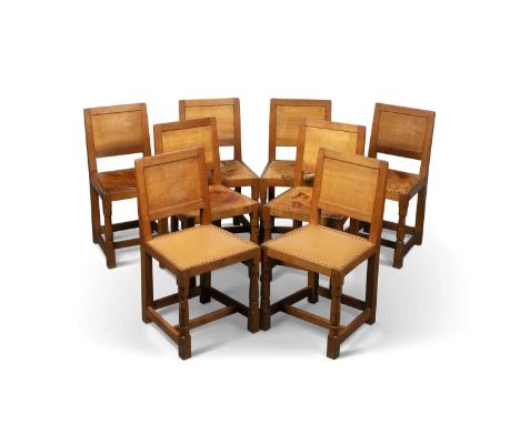 ROBERT THOMPSON OF KILBURN, A SET OF EIGHT MOUSEMAN OAK PANEL-BACK DINING CHAIRS raised on faceted baluster fore legs termina