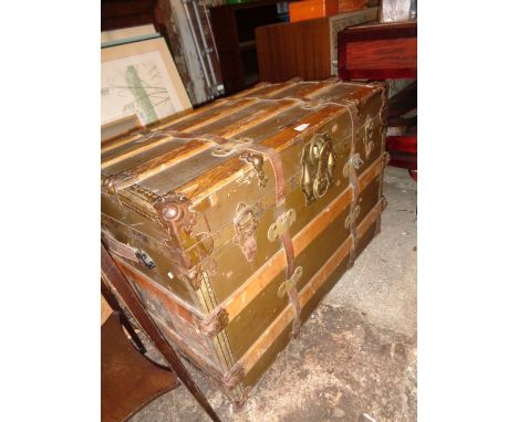 Old steamer trunk with wooden slats over leather bearing the label for R.H. Macy &amp; Co., New York