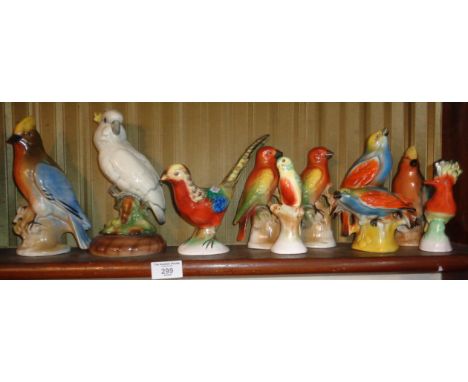 Shelf of brightly coloured 1930's Art Deco bird figurines, inc. a cockatiel by Markay Art Pottery