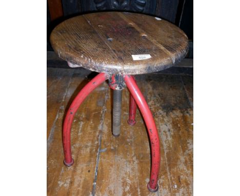Industrial machinist's swivel stool with red painted metal tripod legs