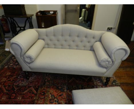 A child's camel back sofa, upholstered in stone linen, raised on fluted column supports and castors