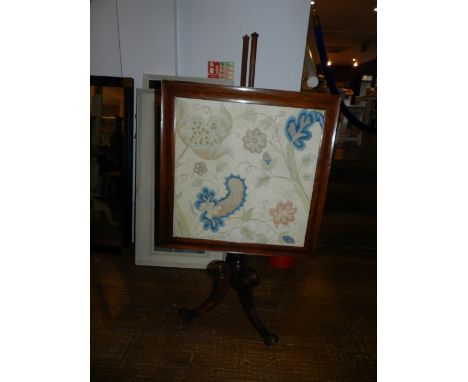 A Regency fire screen, the polychrome tapestry banner worked with flowers and foliage, on a tripod base with scrolling ends, 