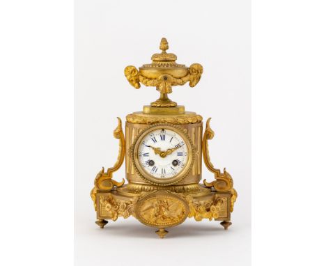 Feuervergoldetes Bronzegehäuse. Pendule in Form eines  Säulenstumpfes mit reich verziertem Sockel auf vier Füßen,  bekrönt vo