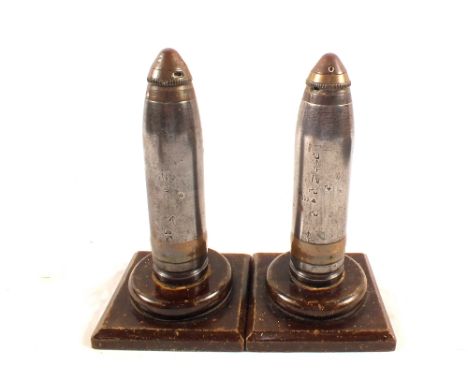 Two rare WWI dated two pounder shell heads complete with timer/fuses on wooden plinths