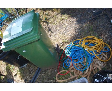 A wheelie bin and assorted rope and pipe.