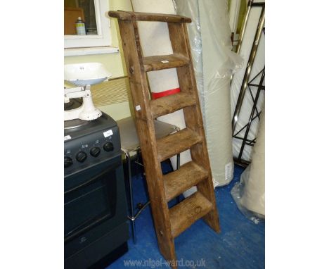 A vintage six-rung wooden ladder.