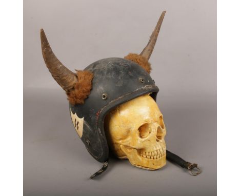 A vintage Hell's Angels style motorbike helmet and heavy cast plaster model of a skull.  