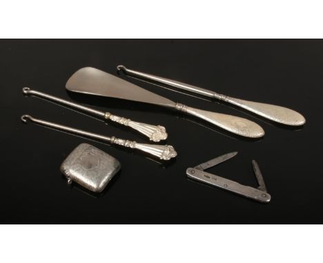 An Edwardian silver vesta case assayed Birmingham 1907, three silver handled button hooks, a shoe horn and an Edwardian silve