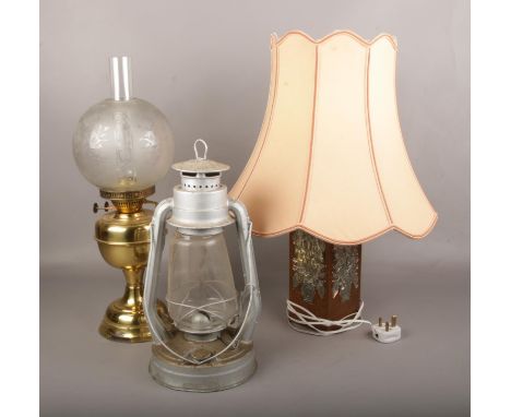 A brass oil lamp, along with a Tornado lamp and a copper table lamp.  