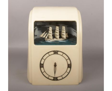 A cream Bakelite Art Deco electric clock with ship automaton by Vitascope Industries, 32cm high.  Not running. Missing a hand