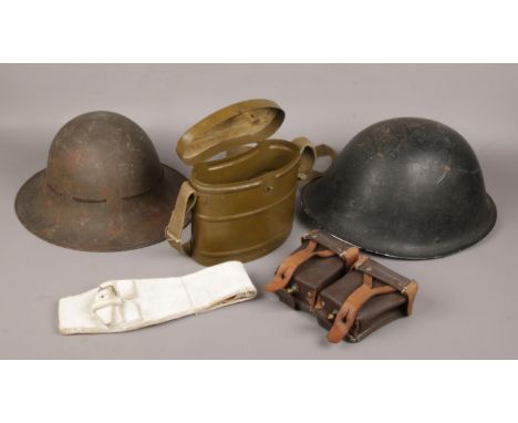 A World War I Zuckerman helmet, similar Brodie type helmet, Russian kidney shaped military canister and a leather ammo pouch.