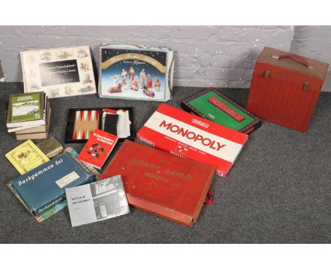 A box of assorted vintage books and games including Monopoly, Monte Carlo Roulette, Backgammon and a boxed coloured bisque Na