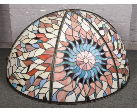 A large Tiffany style half hemispherical stage light shade. Decorated with a central sunburst motif, approximately 140cm, 90c