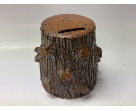 A Leigh pottery money box in the form of a tree trunk.
