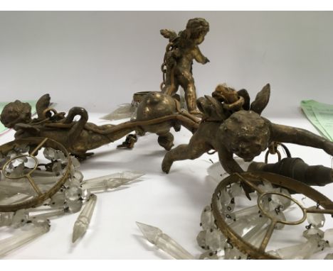 A chandelier in the form of three cherubs with glass drops .
