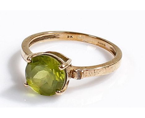 A boxed 9 carat gold ring with Hunan Peridot gemstone flanked by two diamonds, 1.4 grams