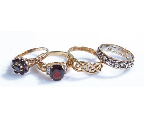 9 carat gold rings, to include a garnet flower head example, a lattice example, a stone set example and an eternity ring, (4)