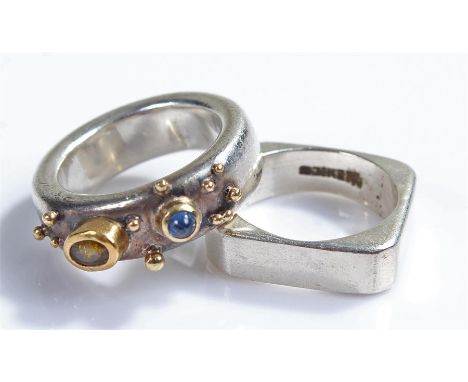 Unusual silver stone set ring, with a cabochon sapphire and brown stone set to the silver ring with raised spheres, together 